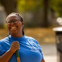 Student holding a shovel & smiling